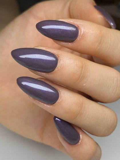 A muted, dusty purple polish with a subtle shimmer on almond-shaped nails. This sophisticated color is a unique alternative to classic nudes or darks.