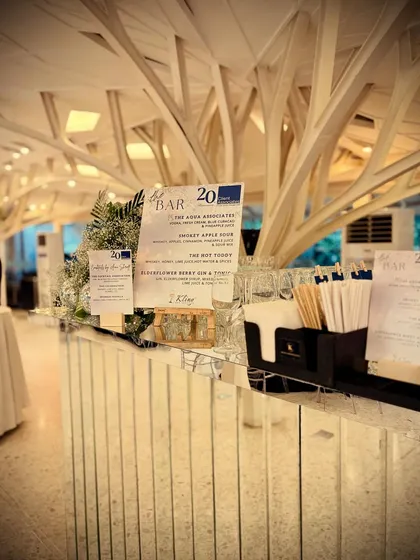 A full view of our sleek, mirrored bar designed for a corporate 20th-anniversary celebration. The clean lines and reflective surfaces complemented the venue's modern architecture, creating a sophisticated and professional look.