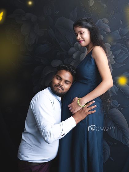 A classic and heartfelt pose where the father-to-be listens to the baby bump against a dark floral backdrop. These moments are precious to capture.