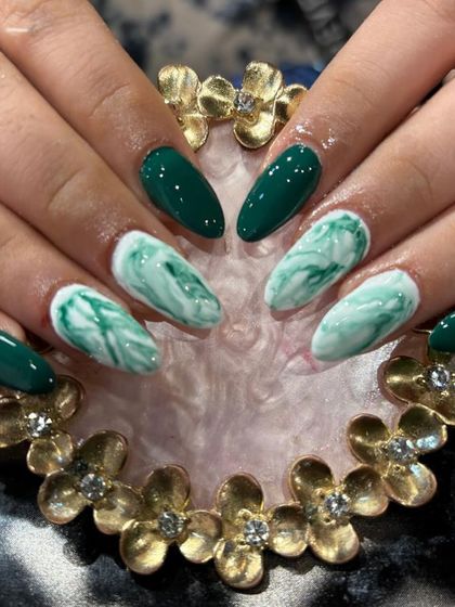 A beautiful emerald green and white marble effect on almond-shaped nails. The mix of solid color and marbled accent nails creates a balanced look.