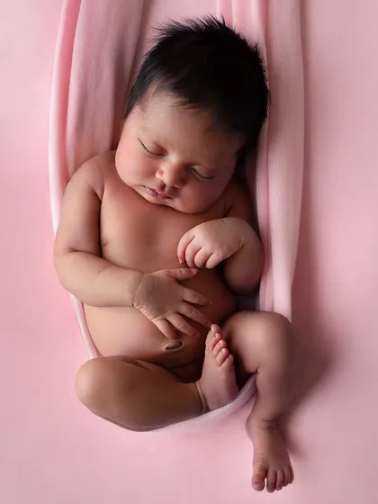 This three-week-old baby girl, with her beautiful honey-toned skin, looks so natural against the dusky rose fabric. A perfect example of how the right color can enhance a portrait.