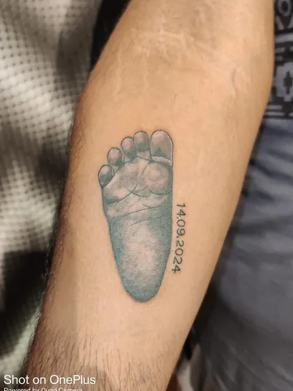 A very personal tattoo for a new parent, featuring their baby's footprint and birth date. I can work with you to create a design that immortalizes these precious early moments.