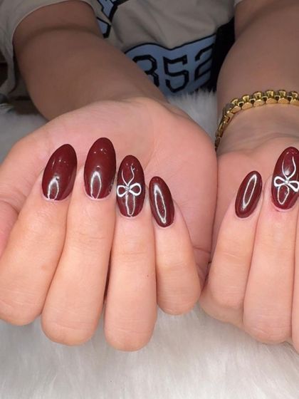 A full view of the elegant maroon coquette nails.
