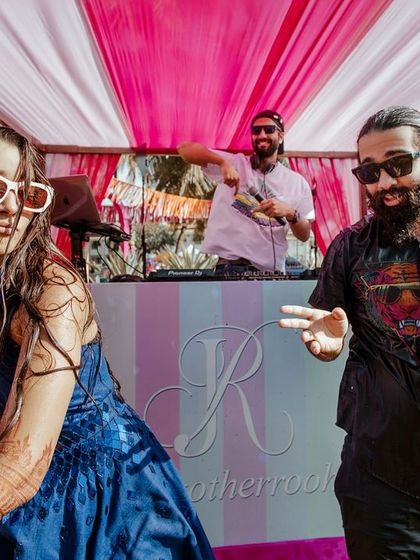 The couple dancing at their beachside party. The vibrant colors of the decor and the happy expressions capture the essence of a fun destination wedding.