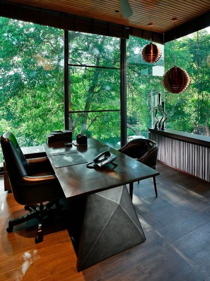 A room with a view. The T House study cantilevers over the garden, sheltered by an Alistonia tree. The floor-to-ceiling glass makes the lush greenery the main backdrop for this space of quiet contemplation.