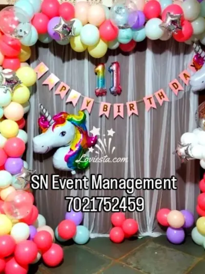 A bright and colorful unicorn theme for an 11th birthday. This setup features a multi-colored balloon arch, unicorn head foil balloons, and a "Happy Birthday" banner.
