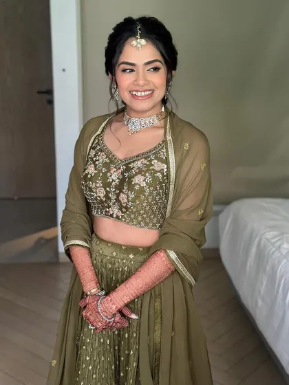 The joy is contagious. Her makeup is designed to be comfortable and long-lasting, perfect for a fun-filled Mehendi ceremony.