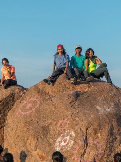 Taking a break on top of the world. A group of climbers relaxes on a boulder, soaking in the views and the good company.