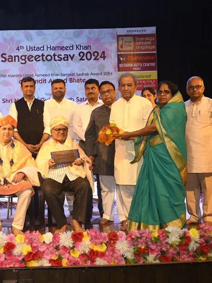 The community coming together to honor the artists and artisans at the Sangeetotsav. This shows the deep respect people have for music and its traditions.