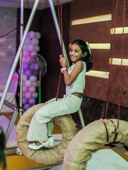 A young girl with a huge smile on her face as she enjoys the tire swing. Her happiness is the ultimate goal of every party I plan.