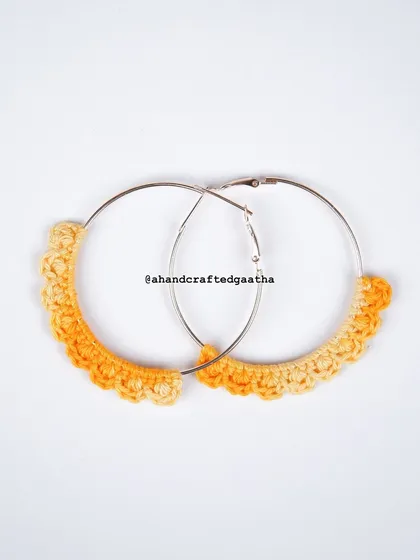 A studio shot of the yellow 'Naazakat' hoops, showing the sunny, two-toned yarn against a clean white background.