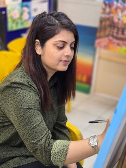 A student at her easel, fully engaged in the process of creating her ballpoint pen artwork in our supportive studio environment.