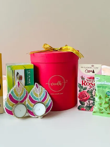 This round red box hamper is another great budget-friendly option. It includes cookies, tea, incense, and beaded leaf T-light holders.