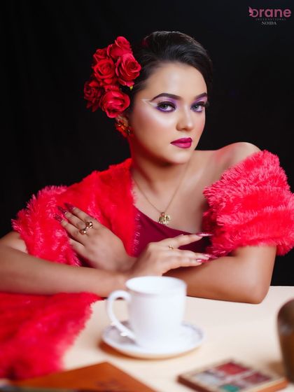 A full view of the look, with a red fur stole and matching floral hairpiece completing the ensemble.