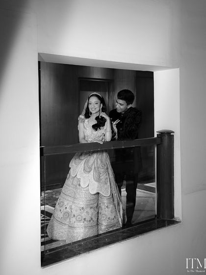 A beautifully framed black and white shot of the couple sharing a quiet moment. Looking through the window gives this portrait a sense of intimacy and artistic flair.