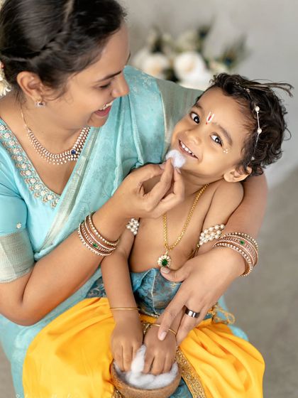 A mother's love for her little Krishna. This candid moment of her wiping butter from his mouth is so playful and sweet.
