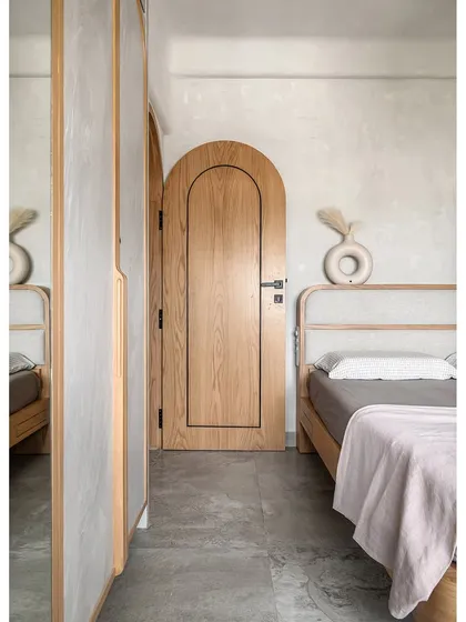 This bedroom is a perfect example of the calm and serenity I strive for with Japandi design. The arched door opens into a zen-like space with a custom fabric-padded bed and warm oak wood. By keeping the material palette minimal and focusing on texture and light, I created a peaceful retreat from the bustle of city life.