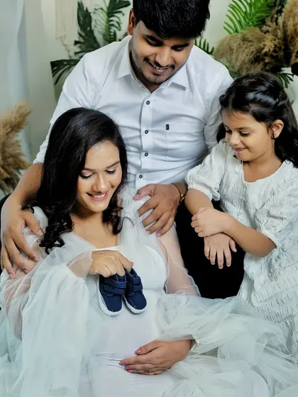 It's a boy! Using tiny shoes is a classic and adorable way to reveal the gender during a family maternity session. The whole family's excitement is captured in this shot.