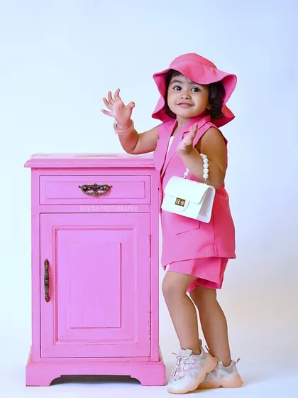 A cute wave to the camera in this stylish kid's portrait.