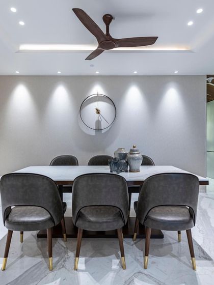 The dining set in the Filigree House, viewed front-on. The composition is balanced and serene, with a large, minimalist clock on the wall adding a touch of graphic interest.