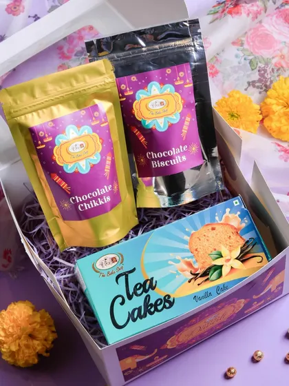 The 'Harmony Gift Box' offers a balanced selection of treats. It contains our popular Chocolate Chikkis, Chocolate Biscuits, and a classic Vanilla Tea Cake, making it a simple yet thoughtful Diwali gift.