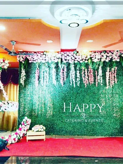 A lovely naming ceremony stage featuring a pink and white floral moon cradle. The backdrop combines a greenery wall with hanging wisteria for a delicate and elegant look.