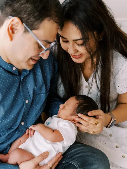 New parents admiring their sleeping baby. These lifestyle newborn photos focus on the bond and emotion of becoming a new family.