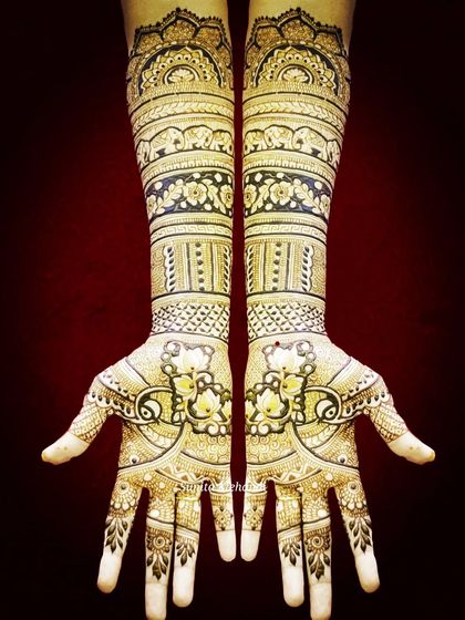 A symmetrical bridal design featuring bands of elephants and floral patterns. The palms have a unique design that comes together to form a complete picture, symbolizing the union of the couple.