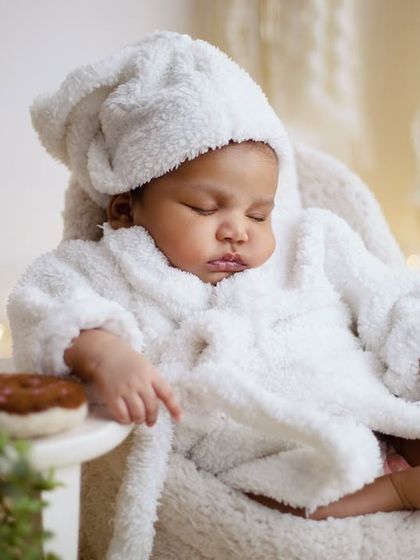 A close-up from our cozy bathrobe session. This shows the little one peacefully snoozing, looking so relaxed and content after a "spa day" in the studio.