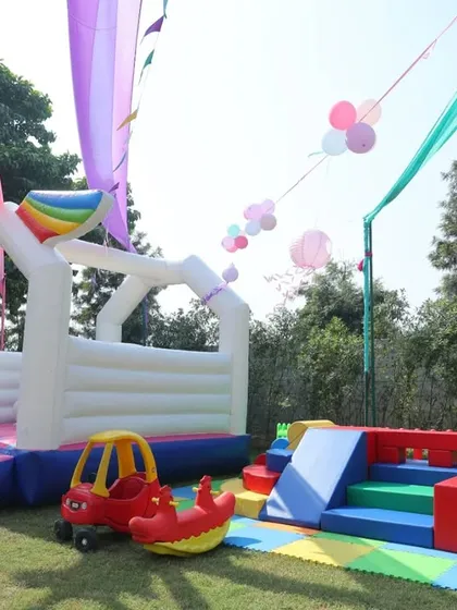 The dedicated play area at the outdoor party, which included an inflatable unicorn bouncy castle and a soft play zone for the younger guests.