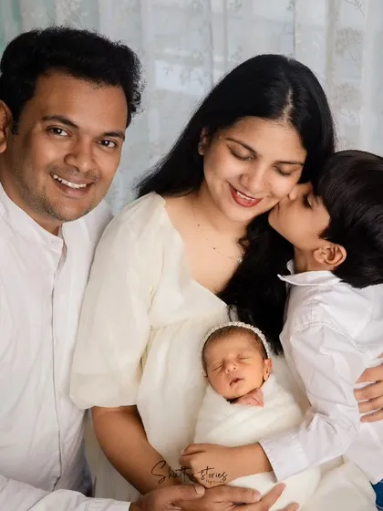 A family portrait that melts your heart. Capturing the tender bond between siblings, as a big brother gives his newborn sister a gentle kiss, is one of the most precious moments in family photography.