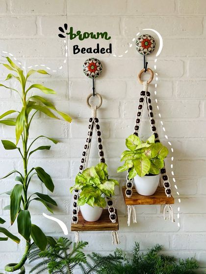 A closer look at our brown beaded macrame wall shelves. These are perfect for small planters and can be styled with our ceramic owl planters to create a rustic and charming display in your home.