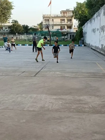 Kids running on the outdoor court during a practice session. This shows the active and energetic nature of our youth basketball program.
