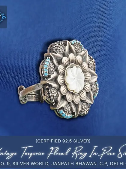 A beautiful vintage-style floral ring, intricately carved from pure 92.5 silver. The center features a mother-of-pearl inlay, surrounded by small turquoise and marcasite stones.