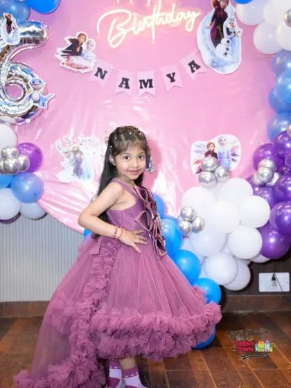 Namya posing in front of her 'Frozen' themed birthday setup. I ensure the decor matches the theme perfectly, from the color palette to character cutouts.