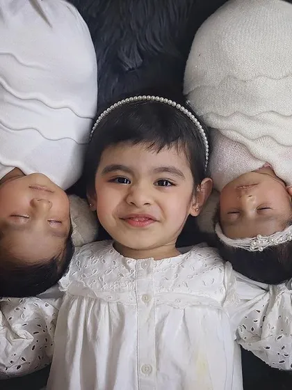 Three souls, one heart. ❤️ An older sister so proud of her new twin siblings. Sibling photos with newborns are so precious, and this overhead shot in classic white is just filled with so much love.