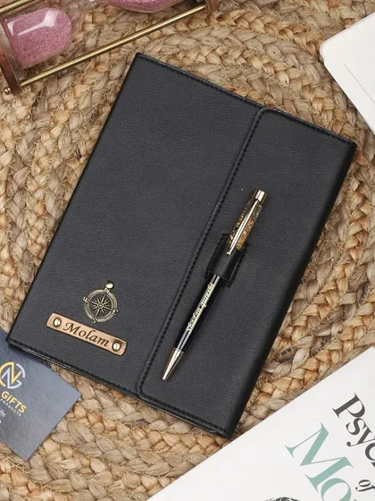 This personalized black diary features a magnetic flap closure and a pen loop, and is customized with a compass charm.