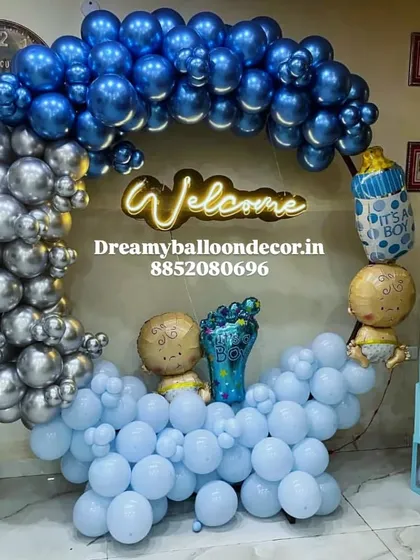 Here's a stylish welcome home setup for a baby boy. I used a combination of chrome silver, light blue, and dark blue balloons for the arch, along with a "Welcome" neon sign and themed foil balloons to make it special.