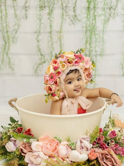 A curious little glance from the baby girl in the tub, surrounded by a beautiful arrangement of flowers.