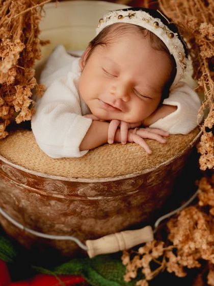 A slightly different angle of the rustic bucket shot, highlighting the baby's serene expression and the beautiful textures of the setup.