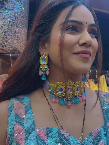 A model wearing the pink and blue beaded choker with a colorful sequined blouse, a perfect pairing for a fun Sangeet night.