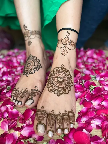 A simple and elegant foot mehandi design, perfect for a beach wedding or a party. The design features a central mandala and a delicate floral anklet.