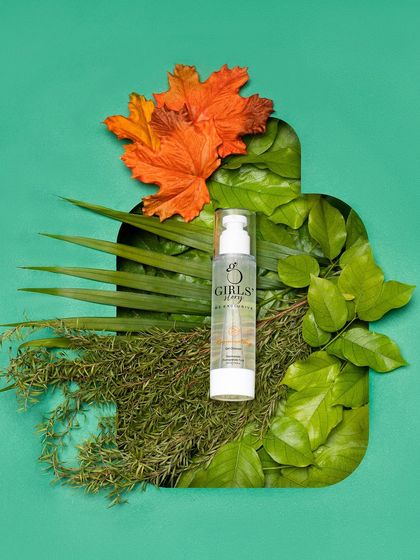 A beautiful flat-lay composition where a skincare bottle is framed by a cutout of lush green leaves. This is a highly creative and artistic approach to product photography.
