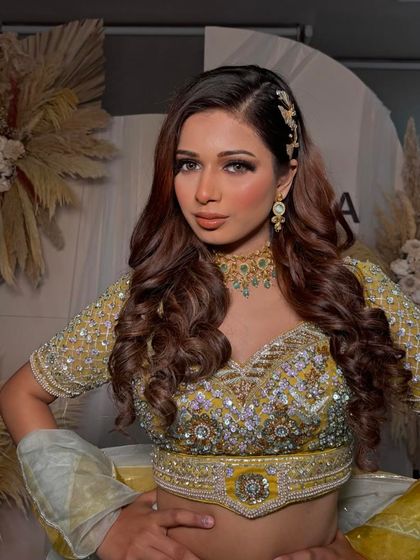 Another one of my favorite creations. This look features a beautiful yellow lehenga, and I created a soft glam makeup look with voluminous curls and a side part.