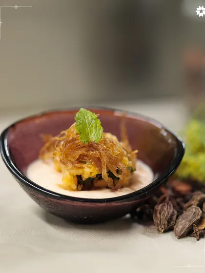 A complex, multi layered bite served in a small bowl. This dish showcases our chefs' ability to combine different culinary techniques to create a unique and memorable flavour experience.