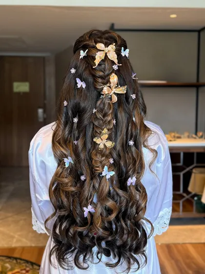 A full back view of the butterfly hairstyle before the bride is dressed, highlighting the length and beautiful curls.