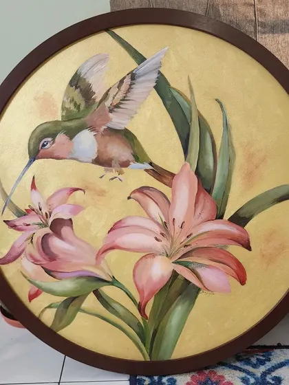 This piece, featuring a delicate hummingbird among lilies, was painted on a custom circular canvas. I used a soft, metallic gold background to give the scene a rich, warm glow, making it a unique and eye-catching piece of nature art for the home.