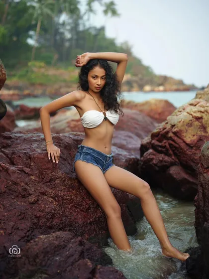 A dynamic pose against the rocks, with the model looking directly at the camera. The combination of the casual outfit and the rugged background creates a strong and confident image.