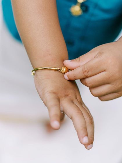 A close-up detail of the little boy's hand and traditional gold bracelet from the ethnic wear shoot.