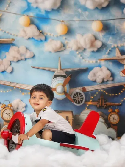 A wide shot of the airplane theme, showing the little pilot smiling as he sits in his plane, surrounded by dreamy clouds and lights.